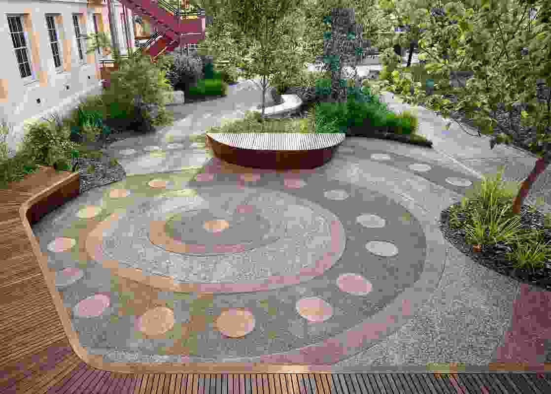 A major gathering space integrates a circular paving design and represents a meeting point within the site.