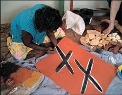 Gulumbu Yunupingu describes the sequence of mark-making to be used. Image: Philippe Ruault