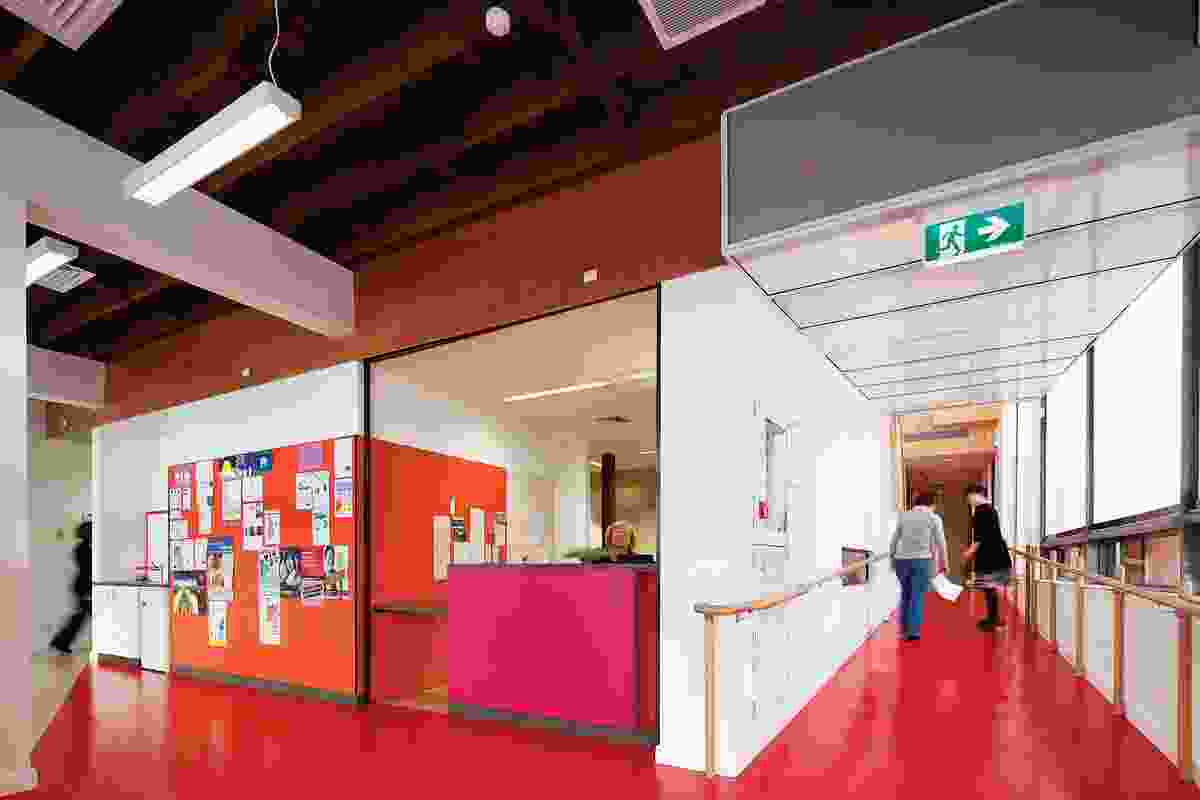 Women’s Health and Family Services. Red vinyl flooring extends from the entry, past the plywood-clad staircase and into the group areas to the right.