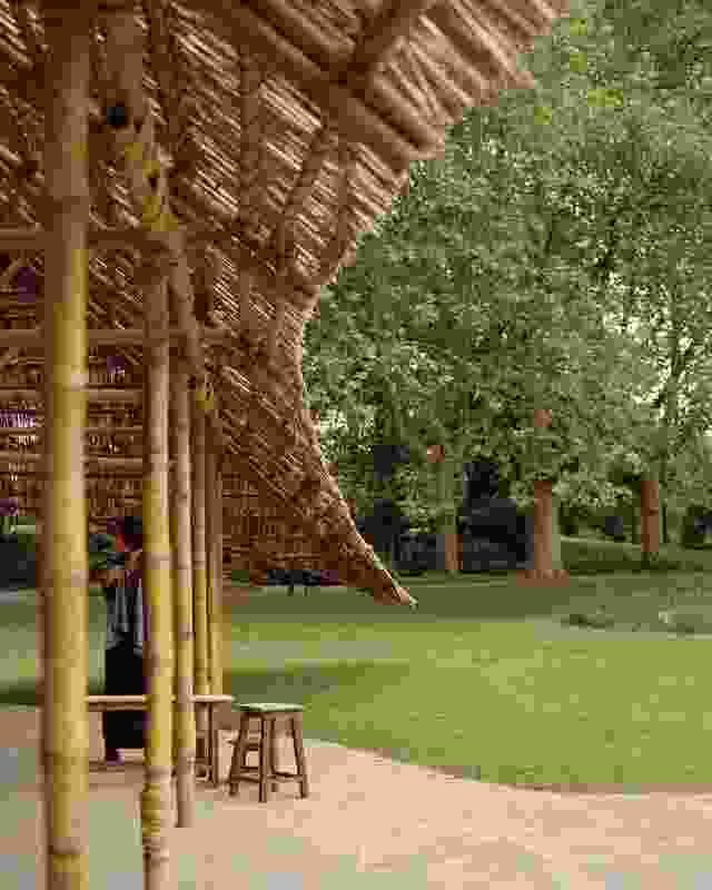 Opposite: The edges of the pavilion’s roof spread beyond the supporting bamboo columns, forming an expansive canopy. 