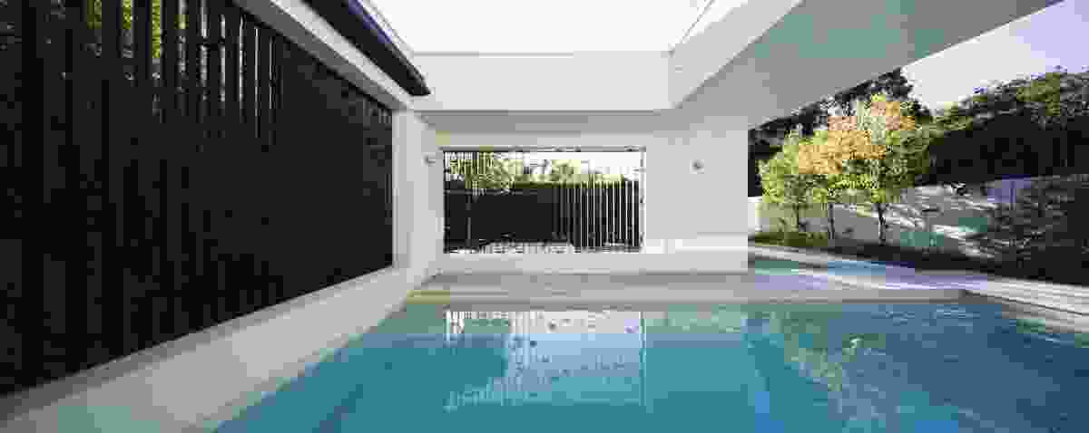 A semi-enclosed pool features black aluminium grilles, braced with fine plates that subtly shift in orientation, vertically and horizontally.