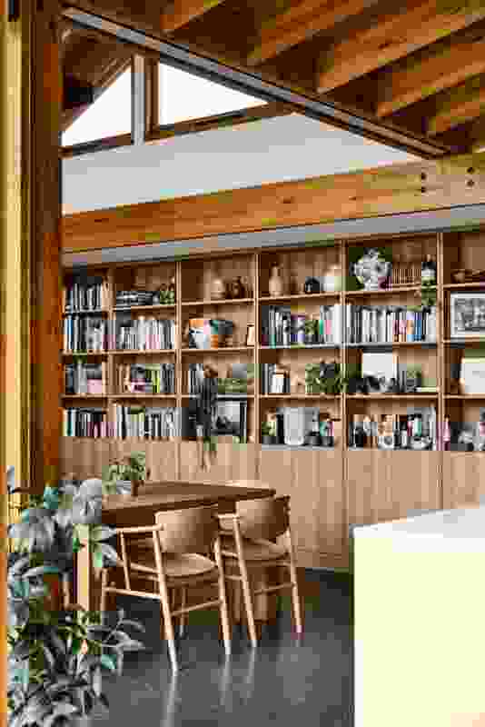 The southern spine of Garden House by BKK Architects is entirely shelves, displaying books and a collection of ceramics.