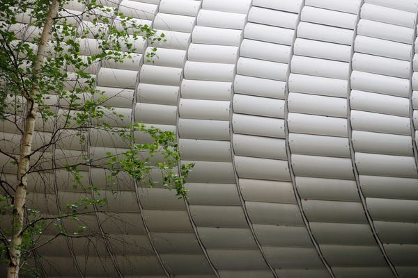 A perforated aluminum screen covers the Pathé Foundation by Renzo Piano Building Workshop to provide privacy and sunshading.