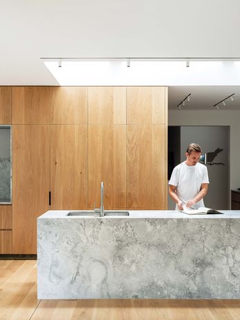 Conceived as a service box in the middle of the house, the kitchen is lit and delineated by two skylights.