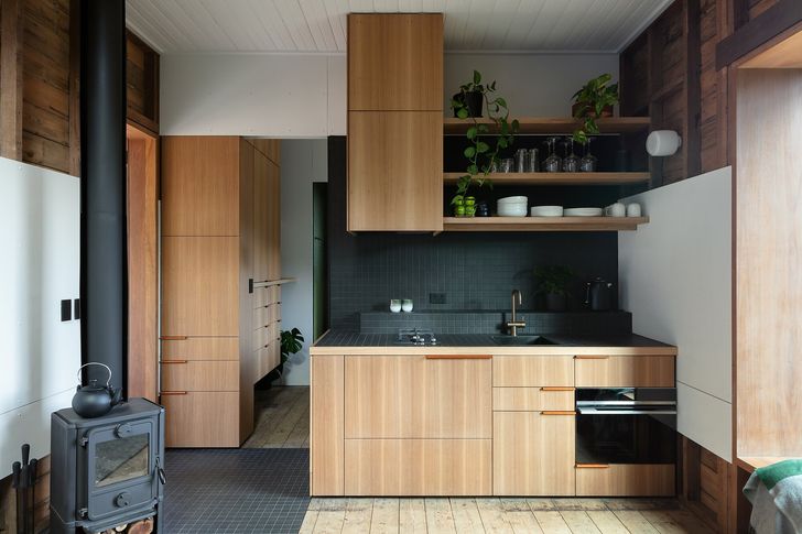 تخته های چوبی اصلی، نازک کاری جدید را در آشپزخانه بازسازی شده کلبه 28 متر مربعی تکمیل می کنند.
