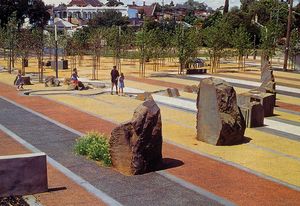 Radial bands of coloured concrete paving framing a central pond reference the fans of dye colour swatches used by the area’s former dye factories.