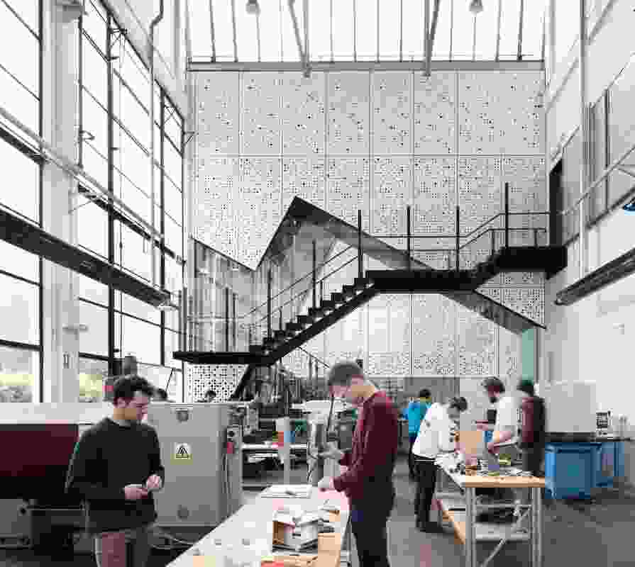 A new linkway within the workshop connects the school’s two courtyards and accommodates a stair with a viewing platform that looks into the workshop.