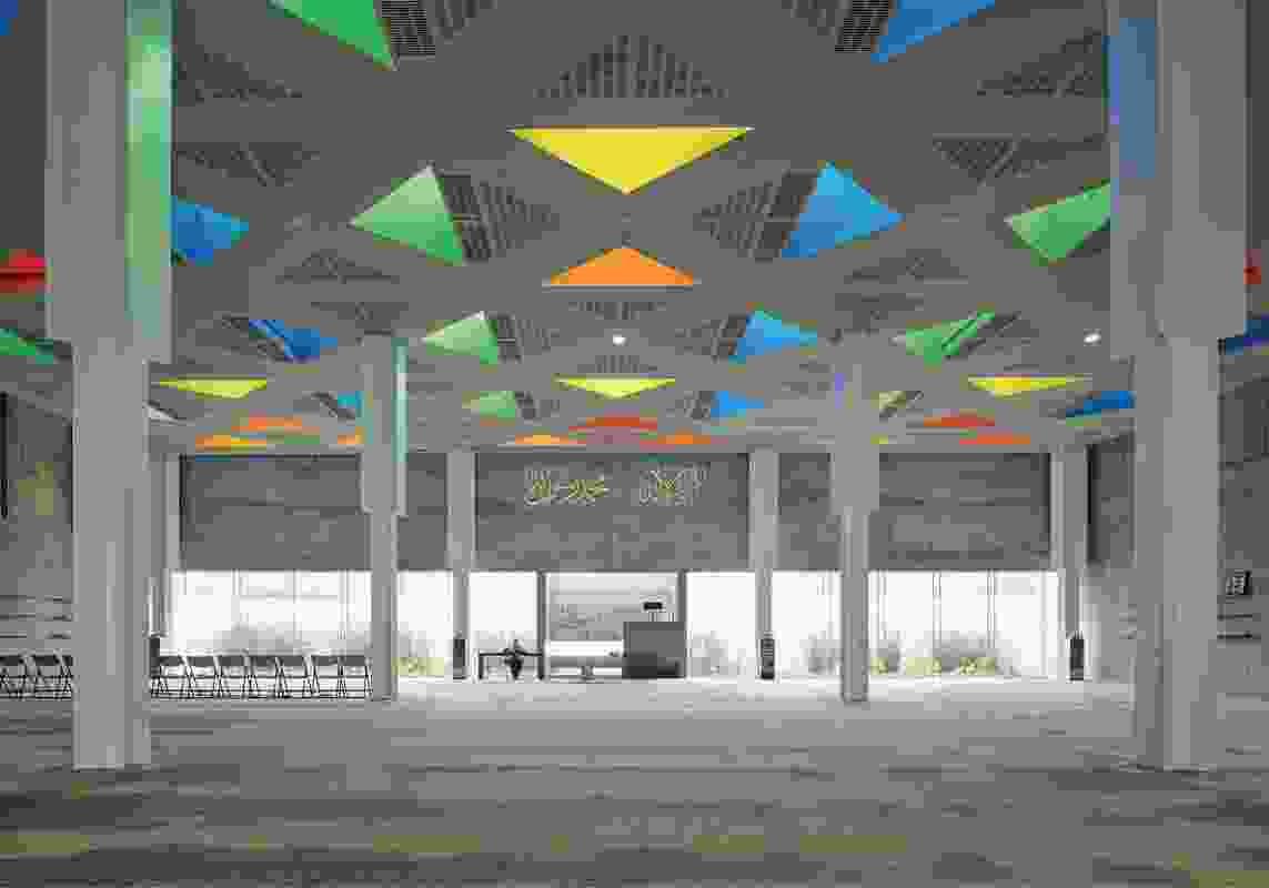 In place of a dome, the building features a flat roof punctured with a series of coloured lanterns that admit natural light to the prayer hall.