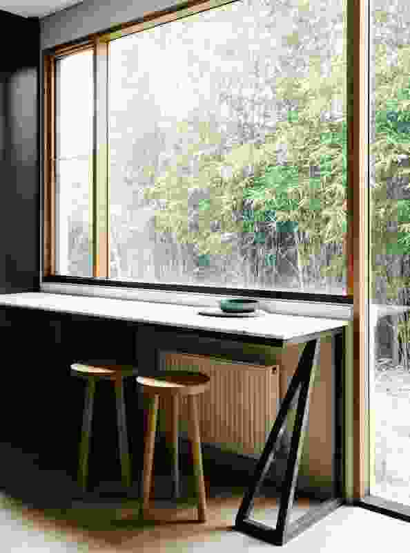 A serene breakfast bar, with simple lines and a palette of black and timber, invites reflection over the east-facing bamboo garden. 