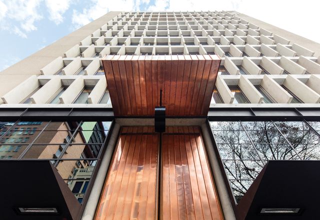 Two-part copper and timber doors, based on a Mexican cathedral, make for a grand and dramatic entry to the QT Melbourne hotel.