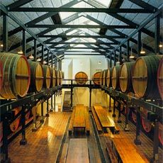 The suspended maturing barrels hover above the trestle tables and stools of the Cask Hall.
