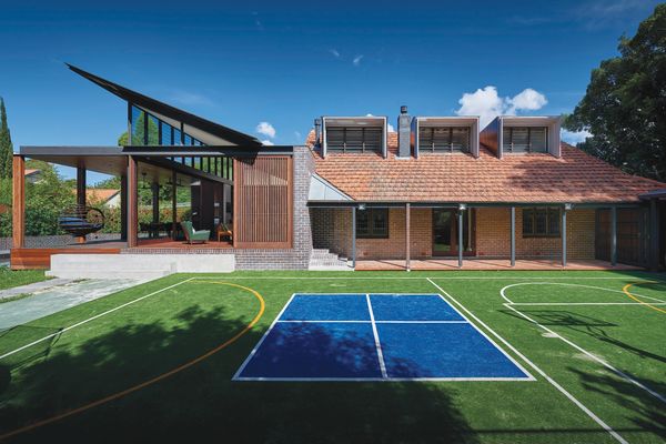 The home borrows shade and a connection with nature from a park to the corner of the site, on the other side of the private tennis court.