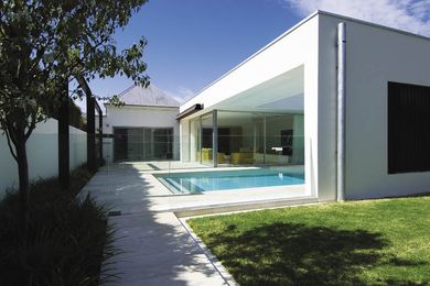The white, rectilinear addition to the rear seamlessly abuts the existing house.