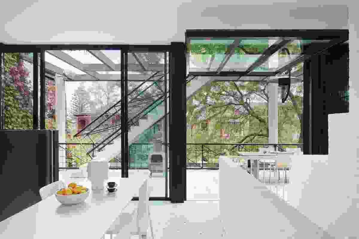 After climbing the first flight of stairs and turning right towards the kitchen, a glimpse of the bay is offered through the pergola, partially obscured by the elevation of the external stair.