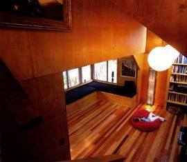 The view down the stairs into the living area, with its mixed hardwood floor.