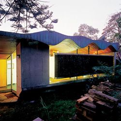 Looking along the bush facade, with undulating roof and “floating” concrete wall panel.