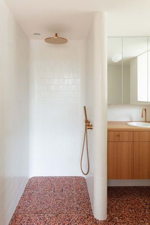 A curved shower recess features an outback-red terrazzo floor, adding a moment of drama.