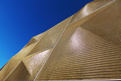 Bronze pyramids to the facade screen glow in direct sunlight: the mesh provides good visibility to those working inside.