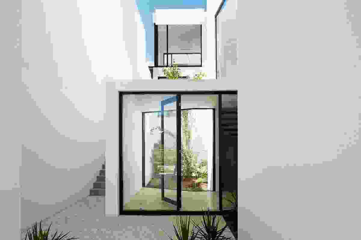 The setback zones allow light and air to enter along the side of each house and an external stair that runs past a sunken garden connects the front and rear of each lot.