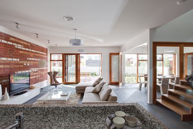 Recycled bricks are artfully arranged to demonstrate the reverse-brick veneer construction as a feature in the living room.