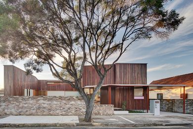 The house is a U-shape around a front courtyard hidden behind a modest brick wall.
