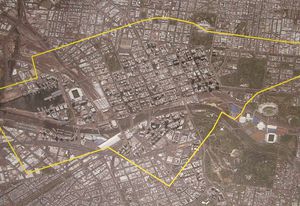 The Hazelwood Open Cut Mine boundary plotted in yellow over an aerial image of central Melbourne at the same scale.