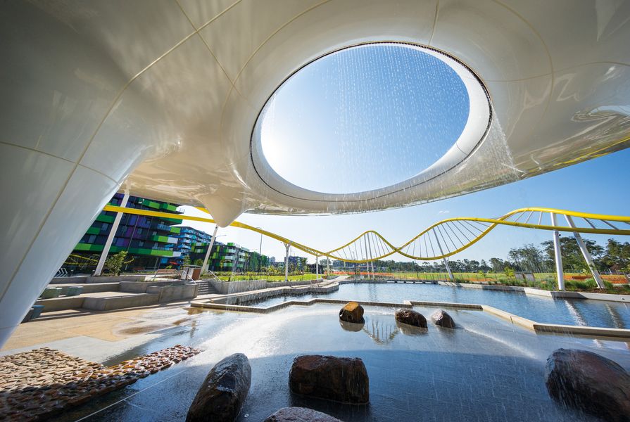Water cascades through an oculus in the Disc, which offers shade and evaporative cooling, while providing a visual anchor to the Village Heart and main park beyond.