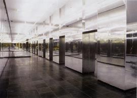 The mirror play of the foyer, clad in reflective glass and stainless steel panels, with a light installation by Stephen Bram.