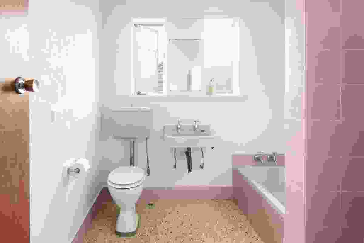 The bathroom retained its terrazzo floor and soft pink and blue porcelain.