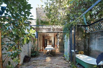 In Waterloo House by Anthony Gill Architects, the original outhouse acts as a threshold point between the outdoor dining and bathing areas.