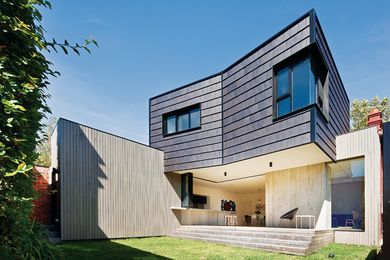 The first-floor addition clad vertically in glazed concrete roof tiles.