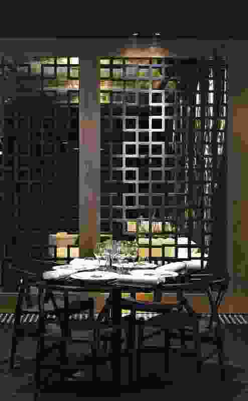 On the dark side, with geometric-patterned screens to separate dining spaces.