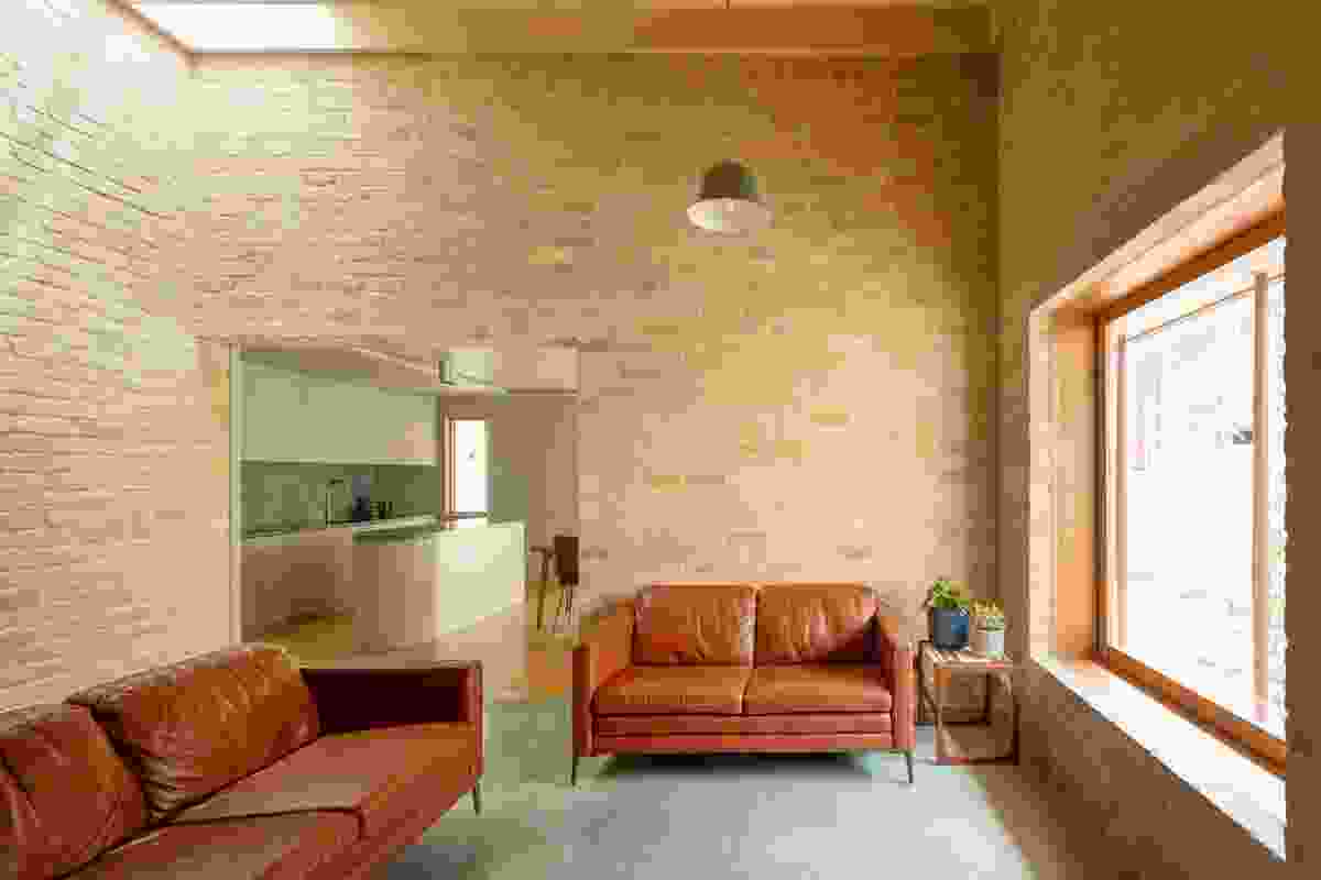 A corner skylight washes light onto the brick wall and emphasizes the scale of the living space.