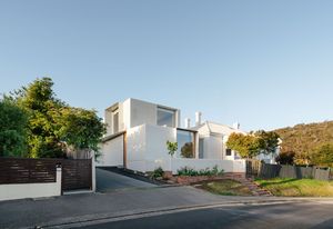 The extension complements the existing white weatherboard exterior, with new windows echoing similar proportions to the original bay windows.