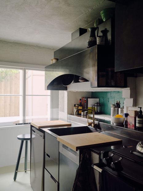 The small-scale kitchen includes chopping board-benches and an end table for optimum functionality.