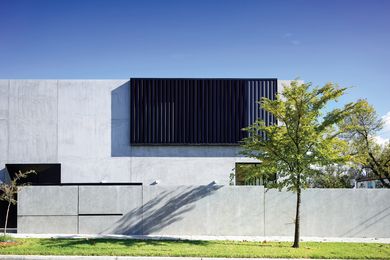 A bold, largely windowless facade caters to the clients' love of concrete and desire for privacy.