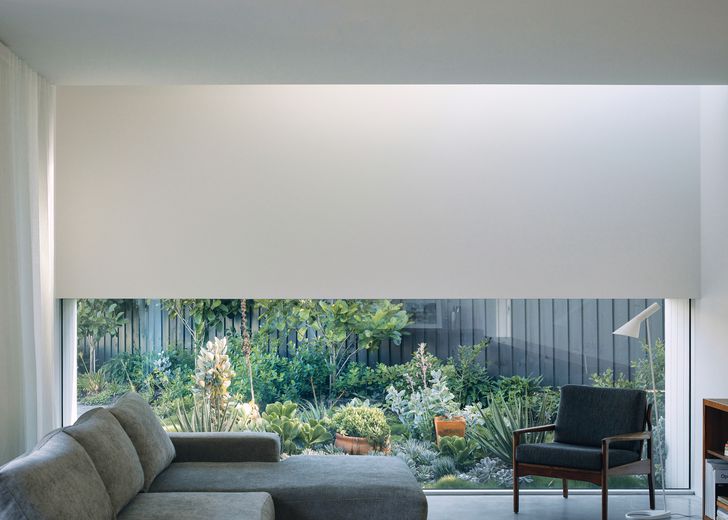 A low window in the family room frames the adjacent garden while editing out views of the adjacent house.