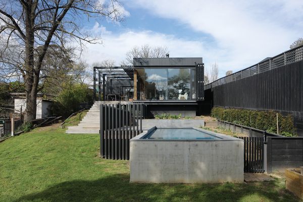 The addition is terraced down the site toward Darebin Creek, connecting all rooms to the bushy surrounds.