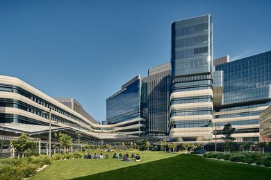 The hospital features a campus-style design with five interconnected buildings arranged around a central green space.