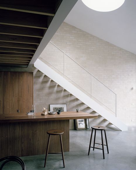 The skillion roof and circular skylight accentuate the volume of the addition. Artwork: Jimmy Pike.