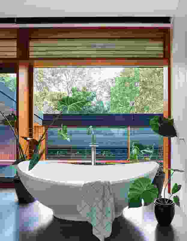 A luxurious bathtub on the upper level affords views across the courtyard to the nearby parklands.