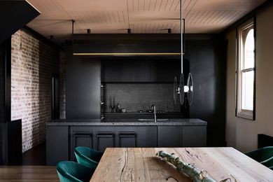 Fine perforated steel fixed to the kitchen's black joinery references the construction of the original building.