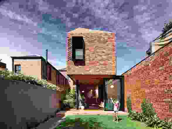 The red bricks of the extension angle up to become a roof, giving cohesion and simplicity to the built form.