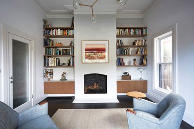 The second living room, at the front, original part of the house, features a fireplace and is lit with ample daylight. Artwork: Faye De Pasquale.