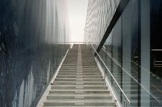 Lateral glass walls capture exterior and interior reflections at the Petter Dass Museum in Norway, superimposing images of nature and architecture.