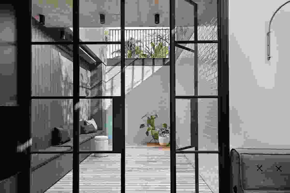A sunken courtyard, lined with pale green tiles, captures northern light, making the rumpus room bright and inviting.