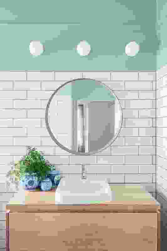 The green paint chosen for the bathroom, also referenced in the kitchen pendant lamp, assists in creating a tranquil space.