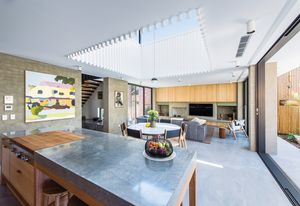 A void above the living areas lets plenty of light in, which is perfect for the owners, who spend a lot of time entertaining in the kitchen. Artwork: Michael Muir.
