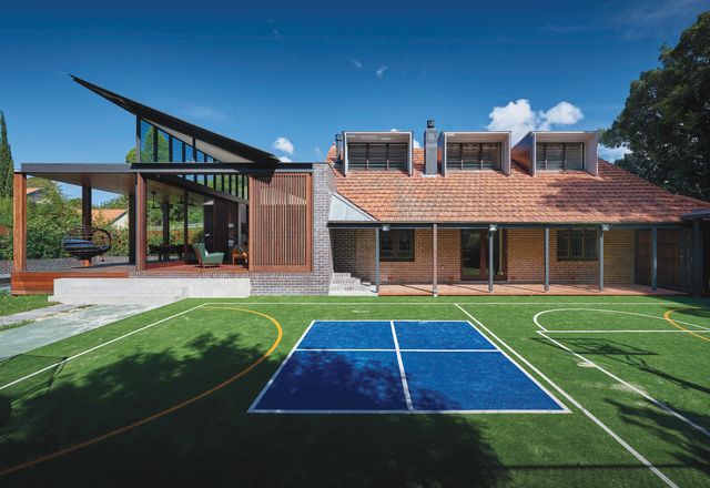 The home borrows shade and a connection with nature from a park to the corner of the site, on the other side of the private tennis court.