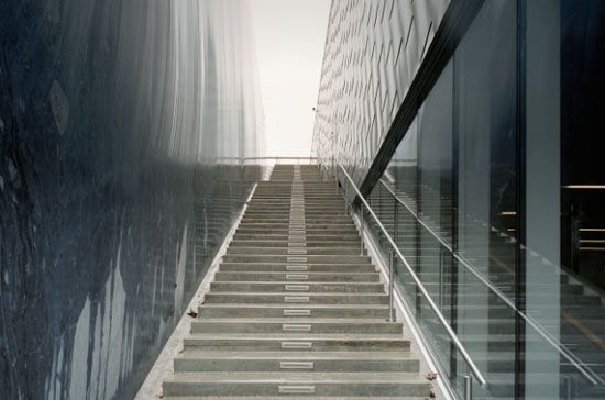 Lateral glass walls capture exterior and interior reflections at the Petter Dass Museum in Norway, superimposing images of nature and architecture.
